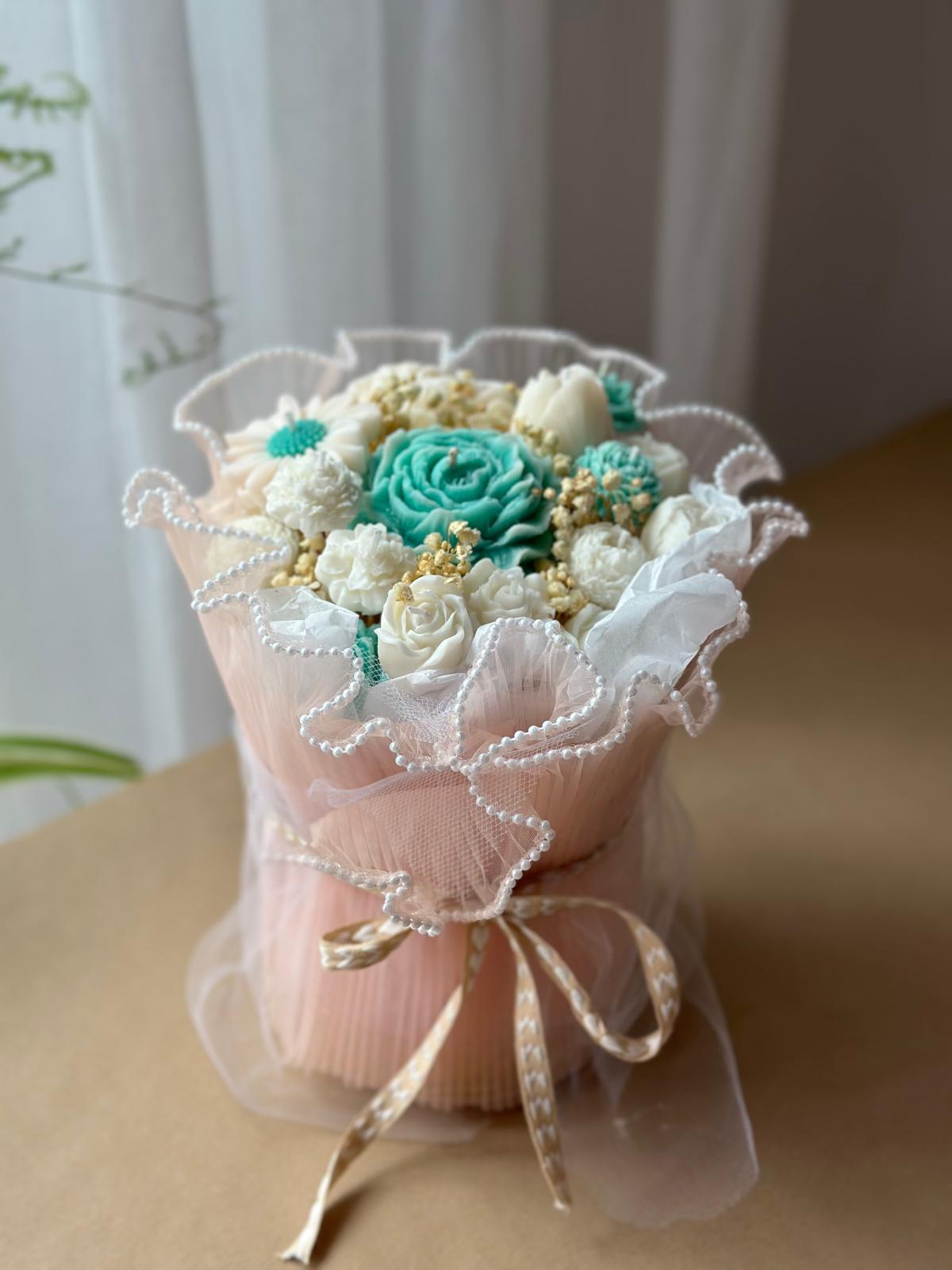 Kleiner Jardin de Roses Kerzenstrauß mit rosafarbener Verpackung, türkisfarbener Kerzenblüte und Schleife