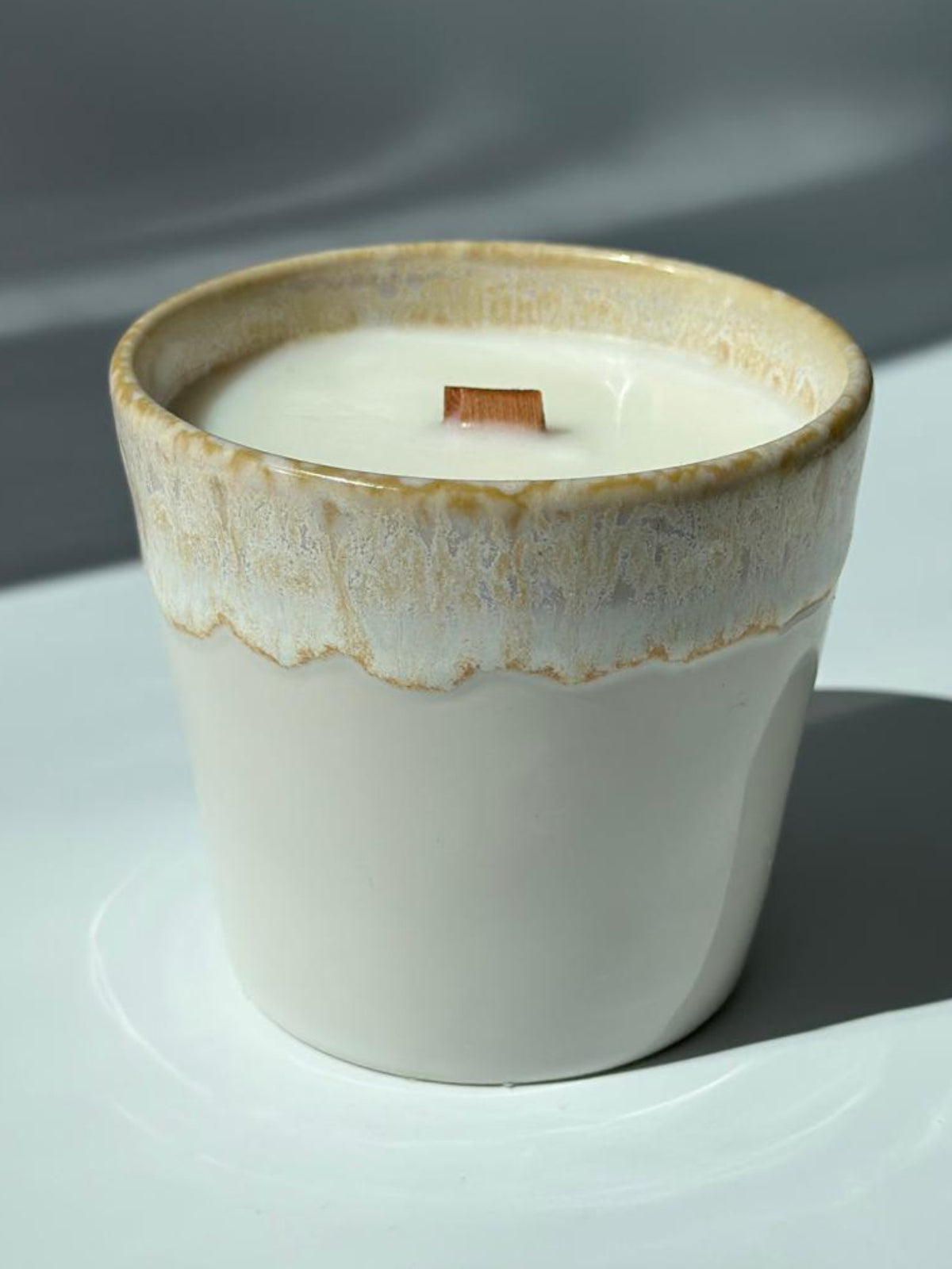 Vanilla Cashmere Sojakerze mit Vanille, Sandelholz und Tonkabohne im hellen Keramikbecher mit Holzdocht, im Sonnenlicht fotografiert